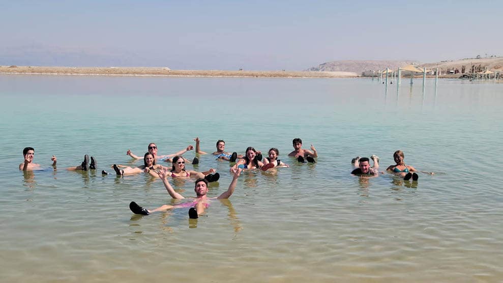 Group shot, smiling teens wading in water