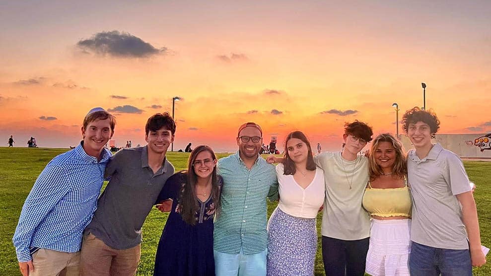 Group shot, smiling teens, sunset in background