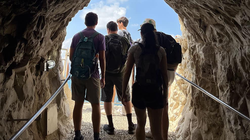 Teens exiting cave tunnel